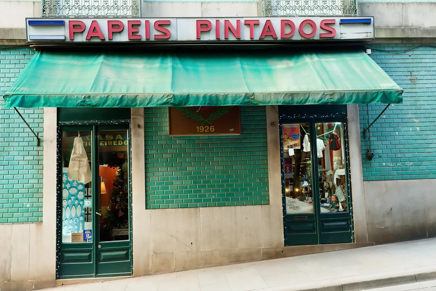 Devanture d'un petit commerce, son enseigne peinte au-dessus de la vitrine